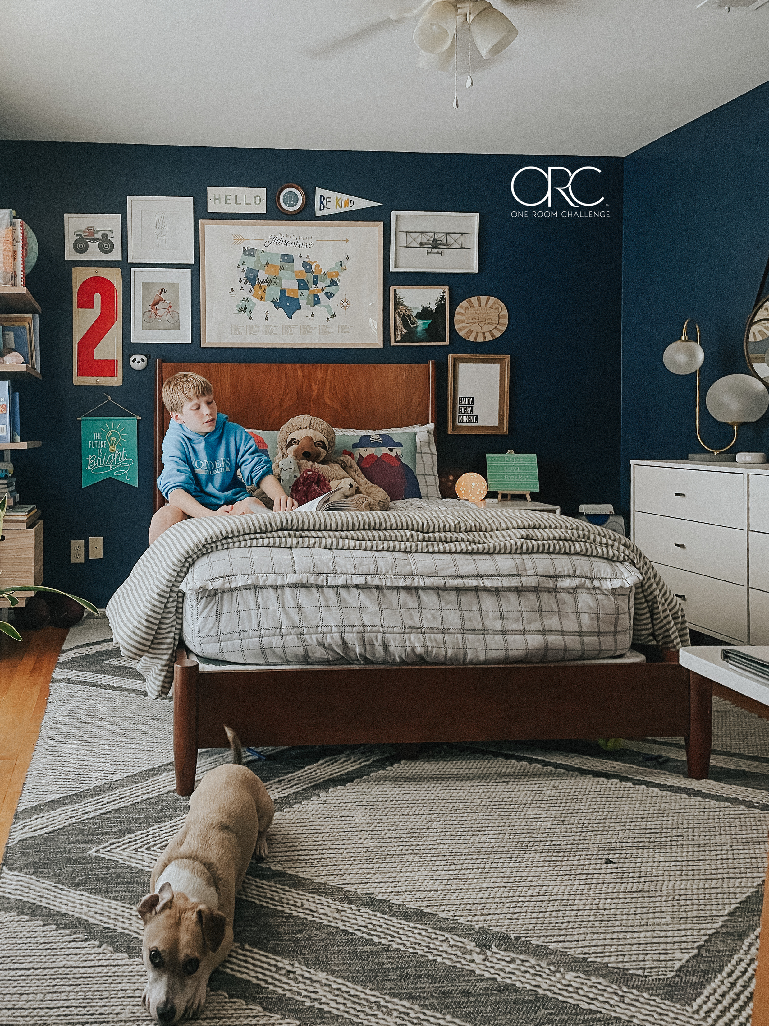 Boy reading on his bed with a gallery wall