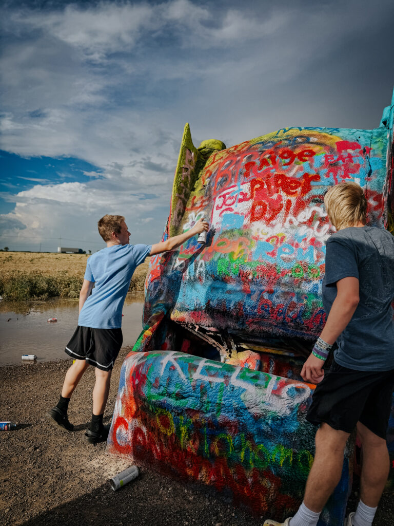 Spray painting at Cadillac Ranch on our Montana road trip from Texas