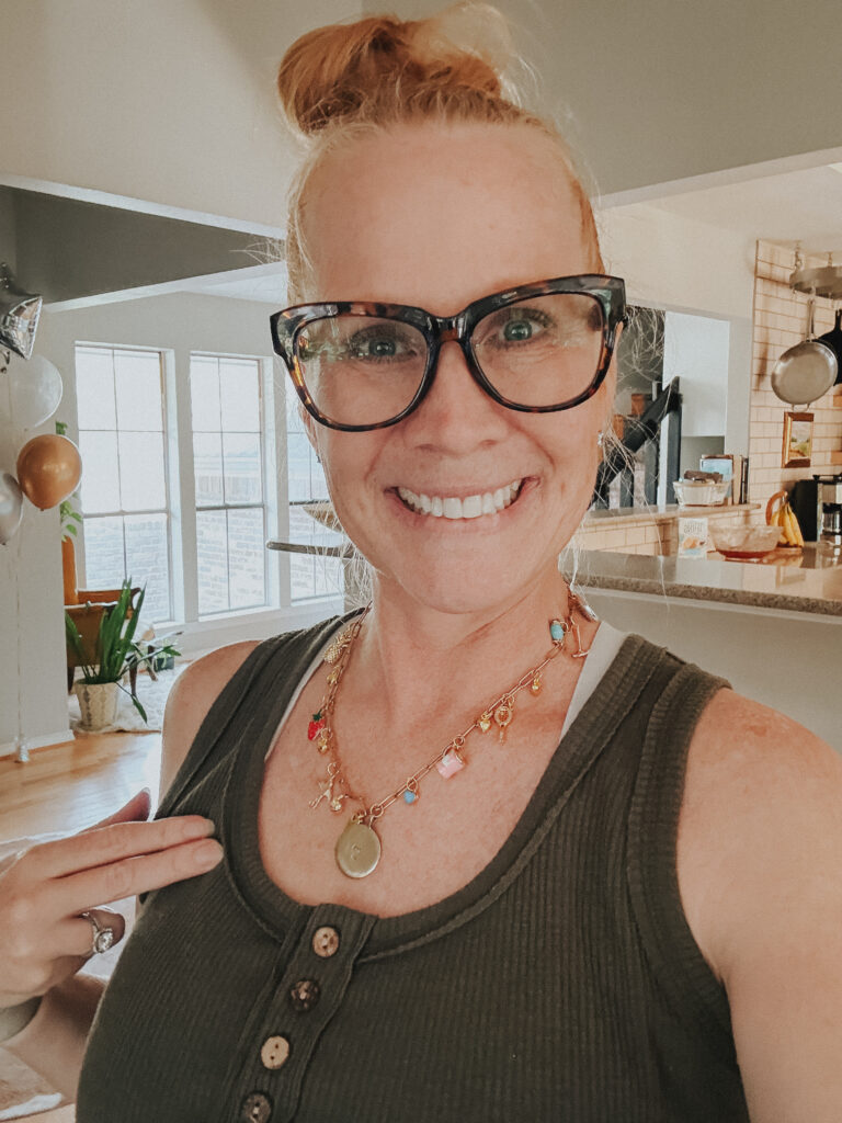 Host of DIY charm party wearing a custom charm necklace made during the event