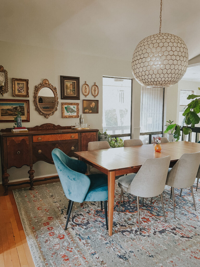 dining room with vintage buffet and artwork. Big round statement chandelier