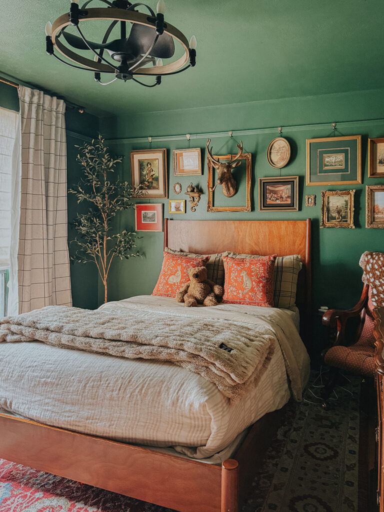 a green color drenched room with vintage pieces and collected gallery wall